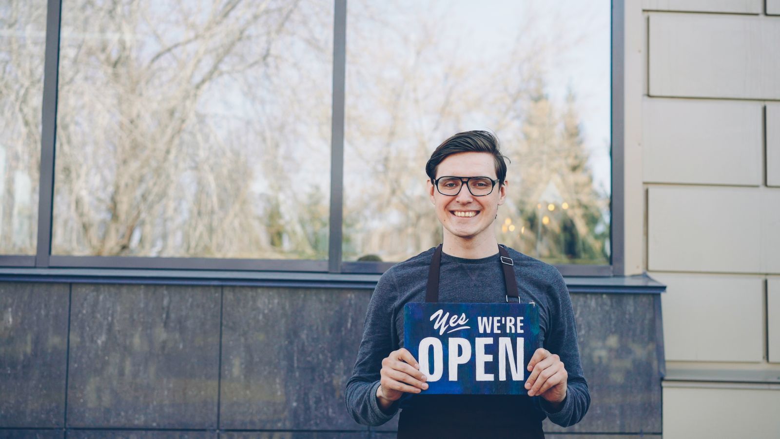 A small-business owner outside their shop